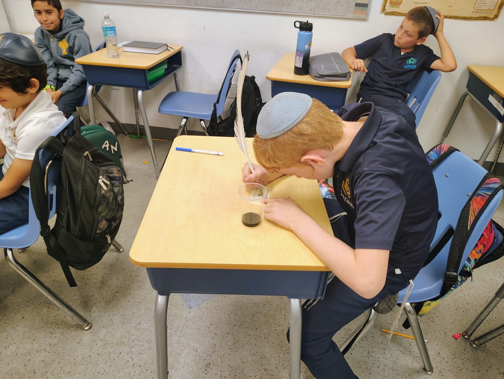 Student writing with a quill at his desk