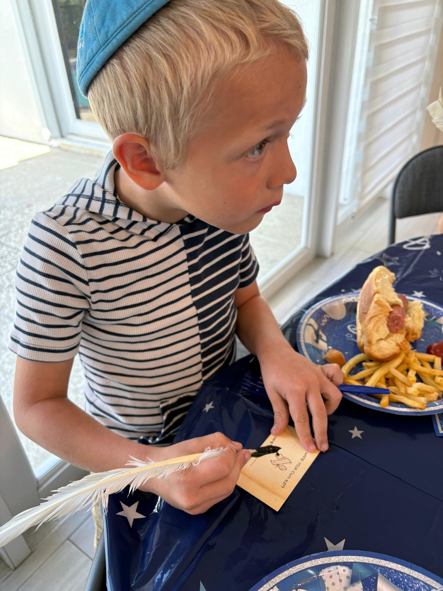 Young boy writing his first aleph